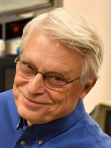 Robert_C._Martin_surrounded_by_computers_(cropped)